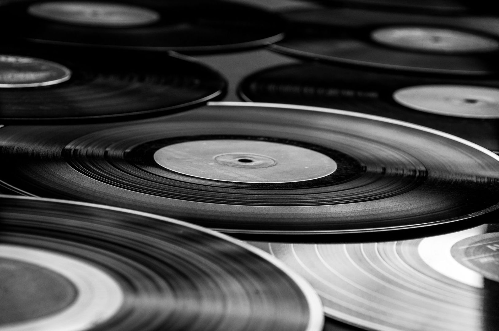 Gros plan en noir et blanc sur plusieurs disques vinyles superposés
