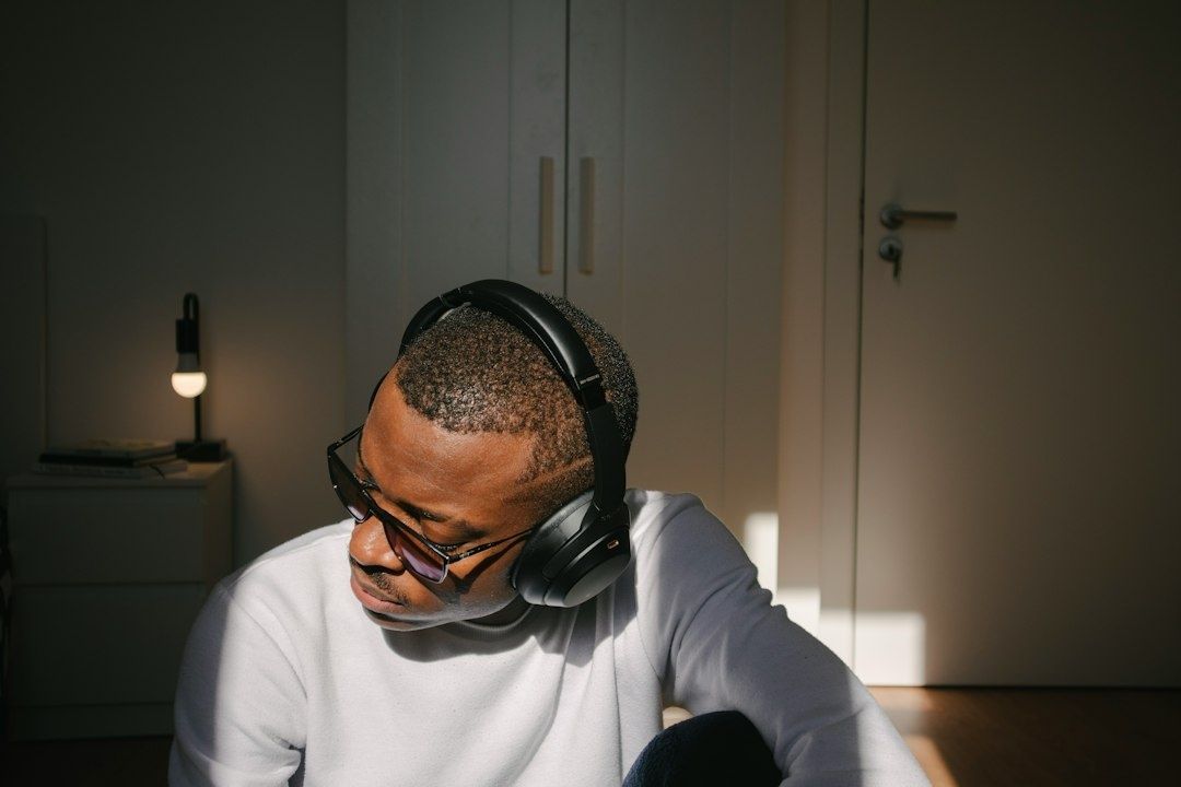 Homme concentré portant un casque audio et des lunettes dans une pièce calme
